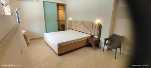 a small bedroom with a bed and a chair at Holiday villa in Lonavala