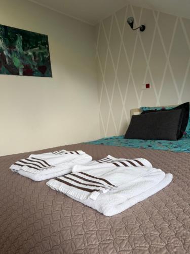 ein Bett mit zwei weißen Handtüchern darauf in der Unterkunft Skrablas Boutique Hotel in Rucava