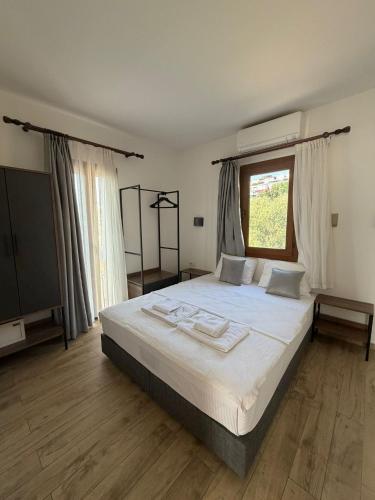 ein Schlafzimmer mit einem Bett mit weißer Bettwäsche und einem Fenster in der Unterkunft Queen Otel in Bodrum City