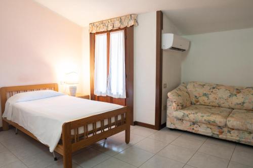 a bedroom with a bed and a couch at Albergo San Lorenzo in Grosseto