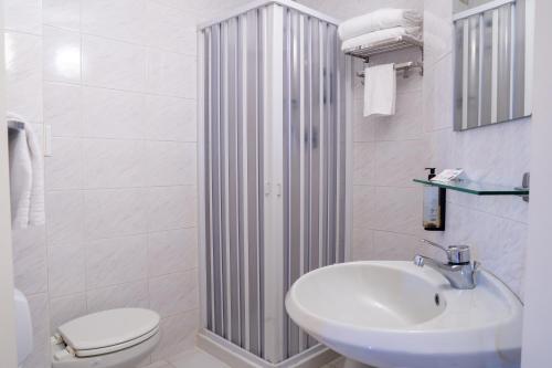 a white bathroom with a sink and a toilet at Albergo San Lorenzo in Grosseto