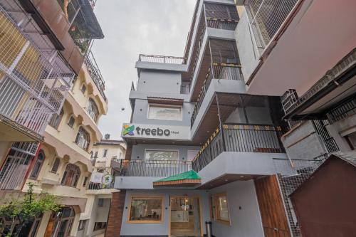 a tall white building with a mexico sign on it at Treebo Sheel, Near Mall Road in Shimla