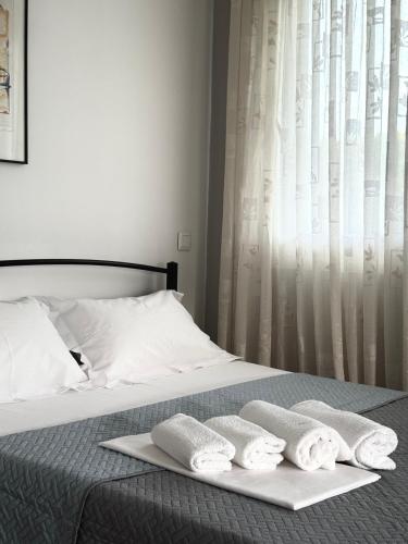 a bed with three towels on a tray on it at Nefeli's apartment in Vonitsa