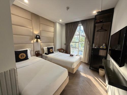 a hotel room with two beds and a flat screen tv at THREE TREE Signature Hotel-G7 Markaz Islamabad in Islamabad