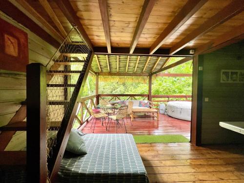 a screened in porch with a table and chairs at Lodge Ti Zaboka , SPA Privatif in Les Abymes