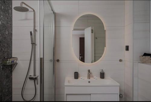 a bathroom with a sink and a shower with a mirror at Dimitra Suites in Pythagoreio