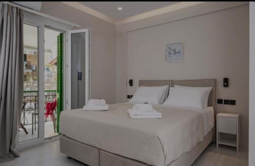a bedroom with a bed with two towels on it at Dimitra Suites in Pythagoreio