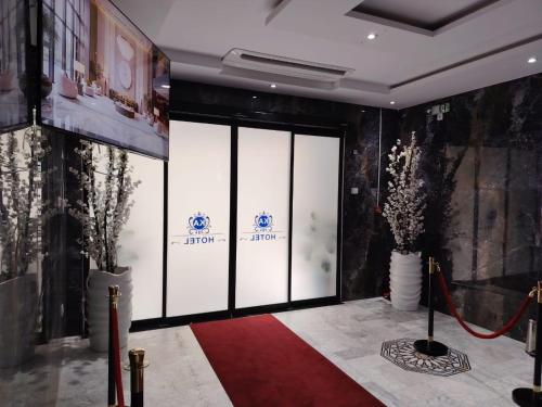 a lobby with a red carpet and glass doors at KA Hôtel Dely Ibrahim in Deli Ibrahim