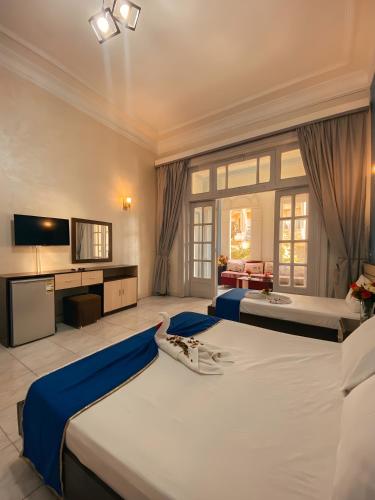 a large bedroom with two beds and a television at Royal Hostgram and Suites in Cairo