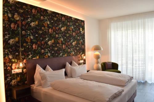 a bedroom with two beds and a floral wall at Lipmanns Boutique-Hotel in Cochem