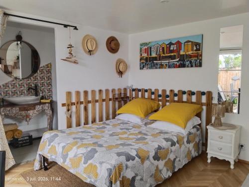 a bedroom with a bed with yellow pillows at Studio CAP à CAP in Mimizan