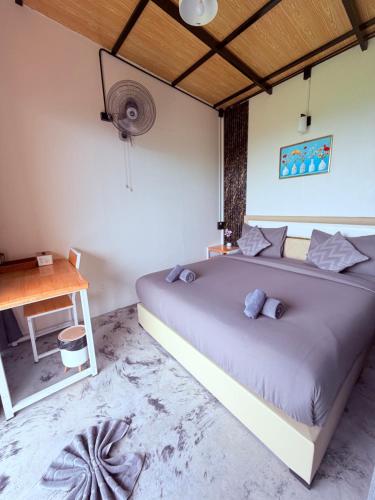 a bedroom with a large bed and a desk at Khaosok Campsite in Khao Sok National Park