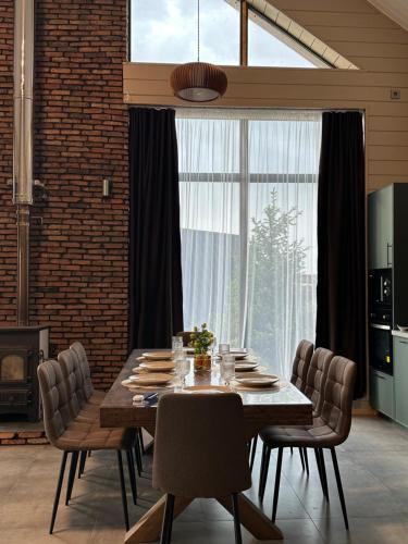 a dining room table with chairs and a large window at Chalet 1391 in Ryskulovo
