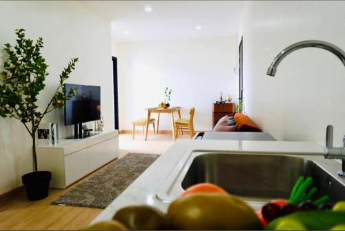 a kitchen with a sink and a living room at condoTip in Loei