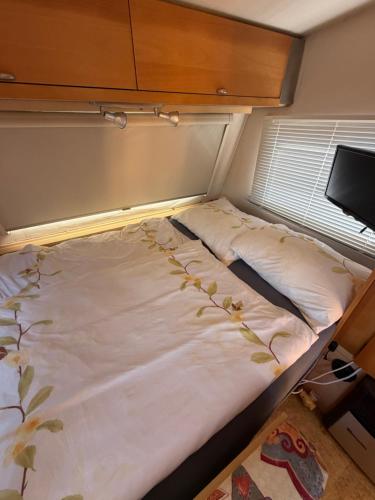 an empty bed in a small room with at Karavan Hrdlička in Čím