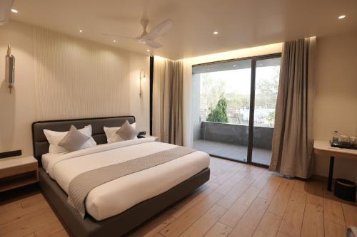 a bedroom with a large bed and a large window at hotel midas in Sāgar
