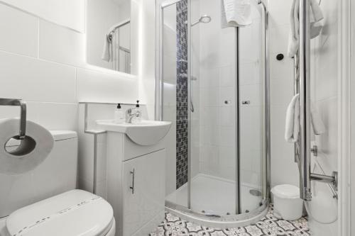 a bathroom with a shower and a toilet and a sink at Beach Front Guest House in Eastbourne