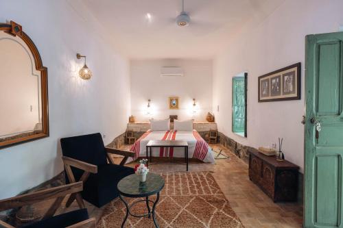 a living room with a bed and a table at Sel d Ailleurs, Ouirgan - adults only in Ouirgane