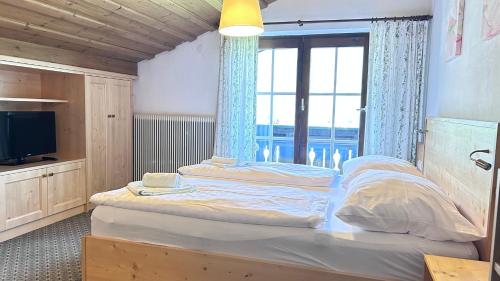 a bedroom with a large bed with a window at Appartementhaus Huber in Abersee