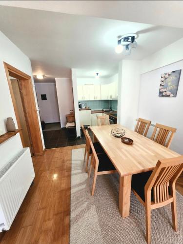 a dining room and kitchen with a wooden table and chairs at Apartment Love in Vlasic