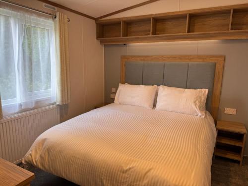 a bedroom with a large white bed with a window at Luxury Lodge in Beverley