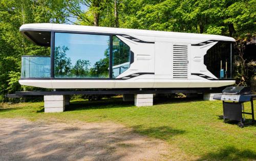 a white bus parked in a grass field at #41 Space Capsule 1-bdr in Parry Sound