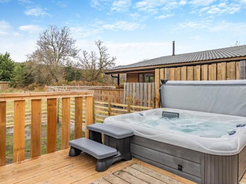 a hot tub on a deck with a wooden fence at Lime Lodge - Uk42547 in Llanwrthwl