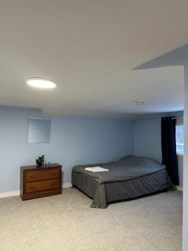 a bedroom with a bed and a wooden dresser at Highway 17 Space Share accommodation in Thessalon