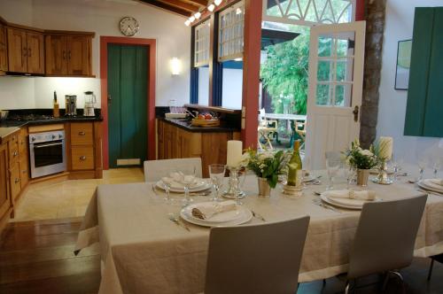 a dining room with a table and a kitchen at Casa Beijaflor in Paraty