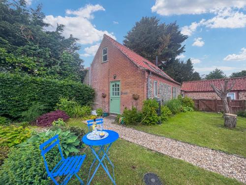 a garden with two blue chairs and a table at The Other House in Briston