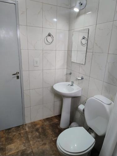 a white bathroom with a toilet and a sink at Haus Eldorado in Eldorado