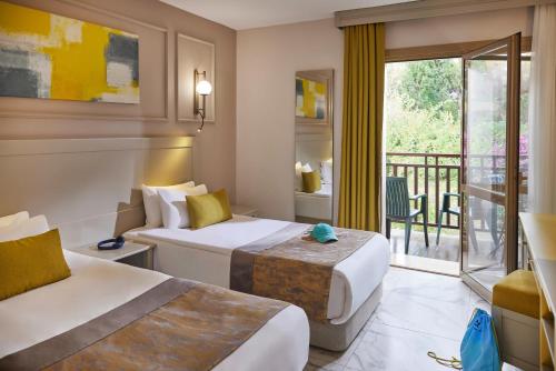 a hotel room with two beds and a balcony at TUI MAGIC LIFE Belek in Belek