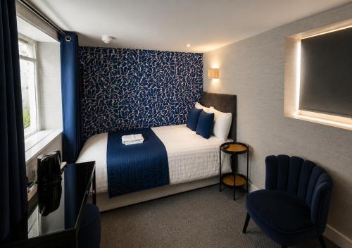 ein Hotelzimmer mit Bett und Fernseher in der Unterkunft Mentone Hotel in London