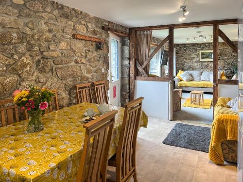 a dining room with a table and a stone wall at Mum's Cottage - Uk52136 in Henwood
