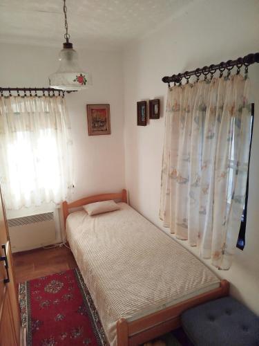 a small bedroom with a bed and a window at Domaćinstvo Nikolić-Milicevo Selo in Požega