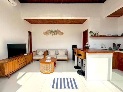 a living room with a television and a couch at Mesari Jinah Villa 1 - 2BR Private Pool Near Melasti Beach Uluwatu in Uluwatu