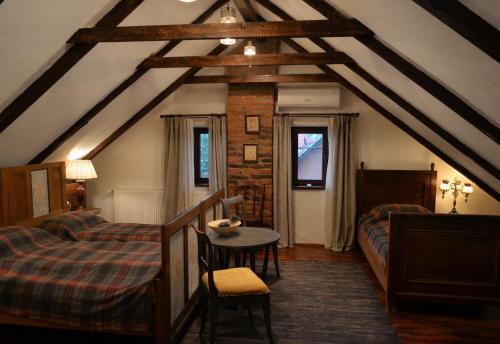 a attic room with two beds and a table at Casa Huber in Cîrţa