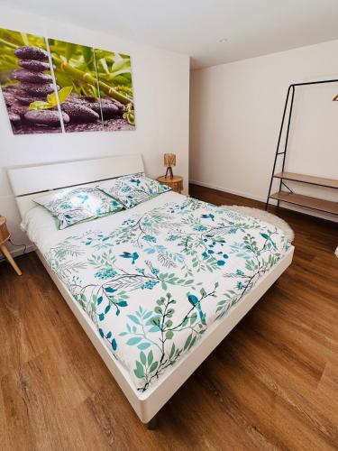 a bedroom with a bed with a floral bedspread at Le Manana in Crozon
