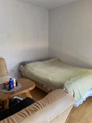 a room with two beds and a table and a couch at Drinska oaza in Zvornik