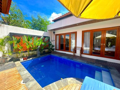 a swimming pool in front of a house at Mesari Jinah Villa 1 - 2BR Private Pool Near Melasti Beach Uluwatu in Uluwatu