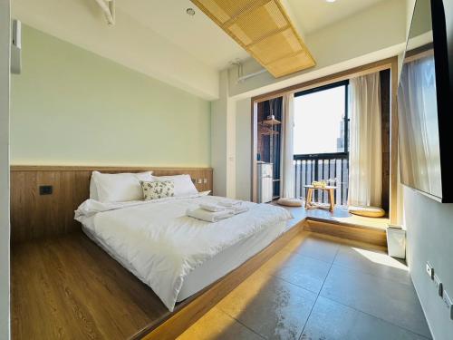 a bedroom with a large bed and a large window at mini嵐輕旅 in Guanyin