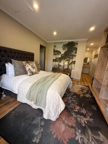 a bedroom with a large bed and a large rug at Zwartmodder Clarens in Clarens