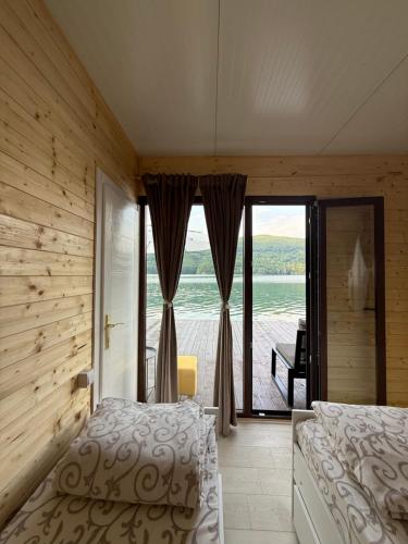a bedroom with a bed and a view of the water at Splav Zoi Perucac in Aluga