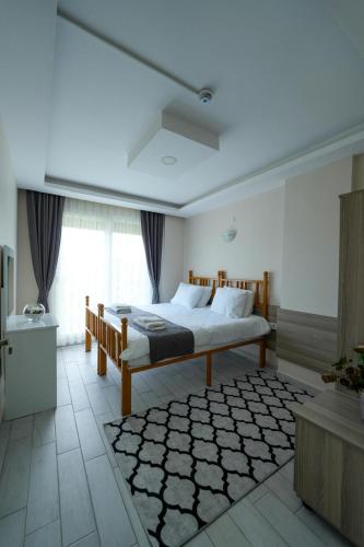 a bedroom with a bed and a large window at İNDAĞ APART AİLE Oteli in Seferihisar