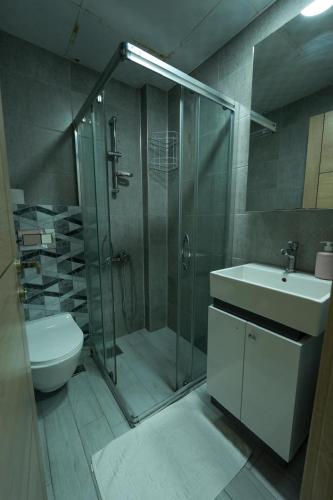 a bathroom with a shower and a toilet and a sink at İNDAĞ APART AİLE Oteli in Seferihisar
