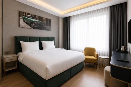 a hotel room with a large bed and a chair at T h e V o i d Hotel - Just Steps From Osmanbey Metro Station in Esenyurt