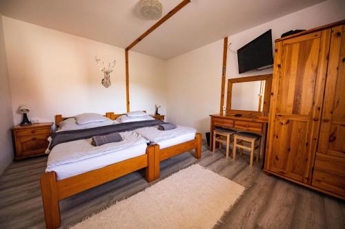 a bedroom with a bed and a dresser and a television at Gyarmati Vendégház Sirok in Sirok