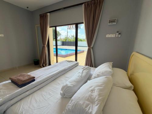 a bed in a room with a view of a pool at Untung5tay in Gua Sai