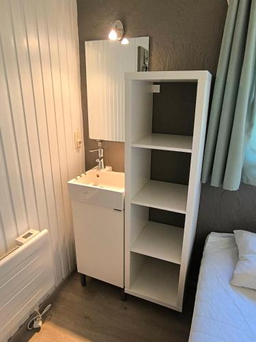 a bathroom with a sink and a cabinet with a mirror at Bungalows du Lac de Rabais in Virton