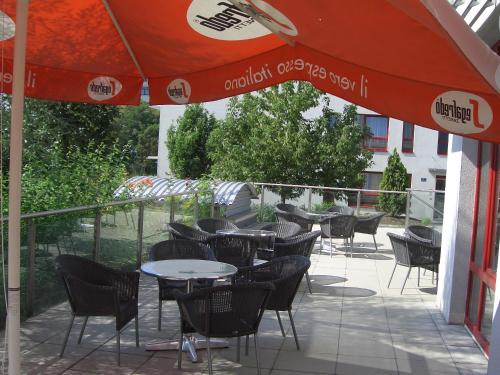a patio with tables and chairs and an umbrella at Kolping Campus Krems in Krems an der Donau